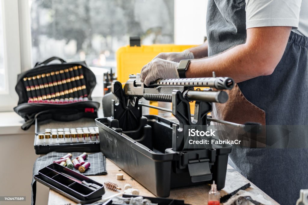 The gunsmith maintaining his shotgun rifle in a workshop Armurier